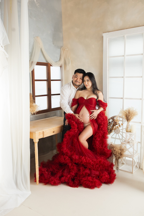 大宮マタニティフォト|おすすめの撮影時期 赤いマタニティドレスを着た妊婦さんのお腹を美しく残すマタニティフォト